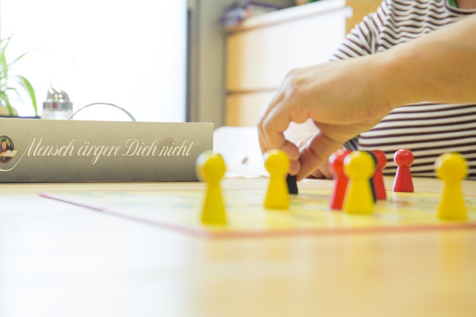 Mensch ägerer dich nicht Spielbrett mit einer Hand in der Außenwohngruppe