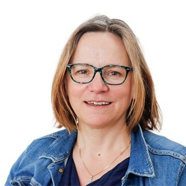 Lächelnde Frau mit Brille und Jeansjacke vor weißem Hintergrund