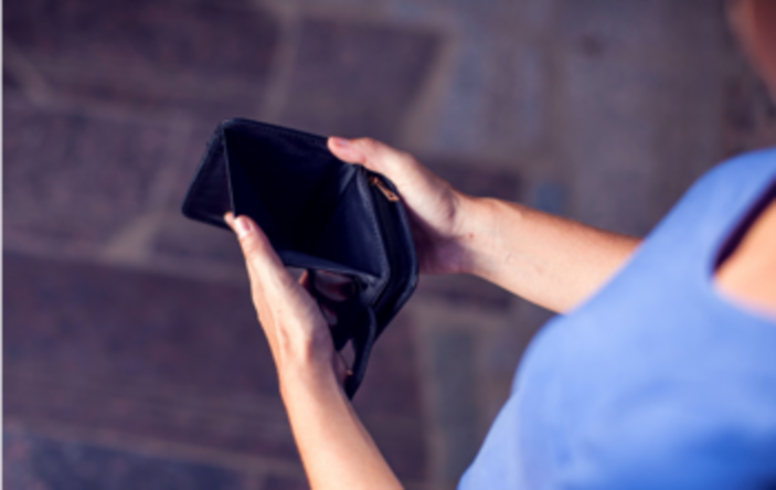 Person hält eine leere Geldbörse in den Händen – Symbol für finanzielle Not