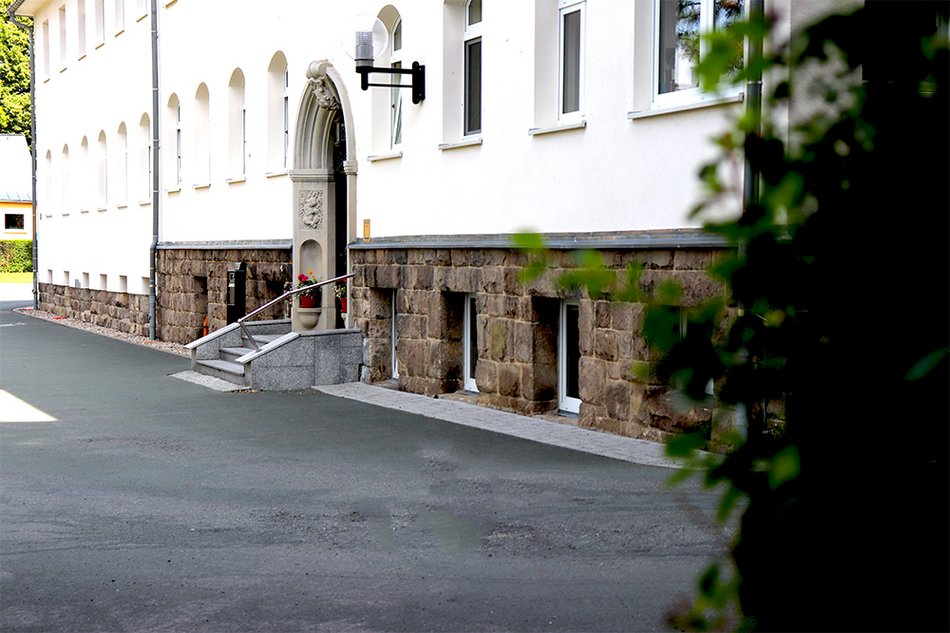 Außenansicht mit Eingang, weißes Gebäude zur Wohnstätte Thum