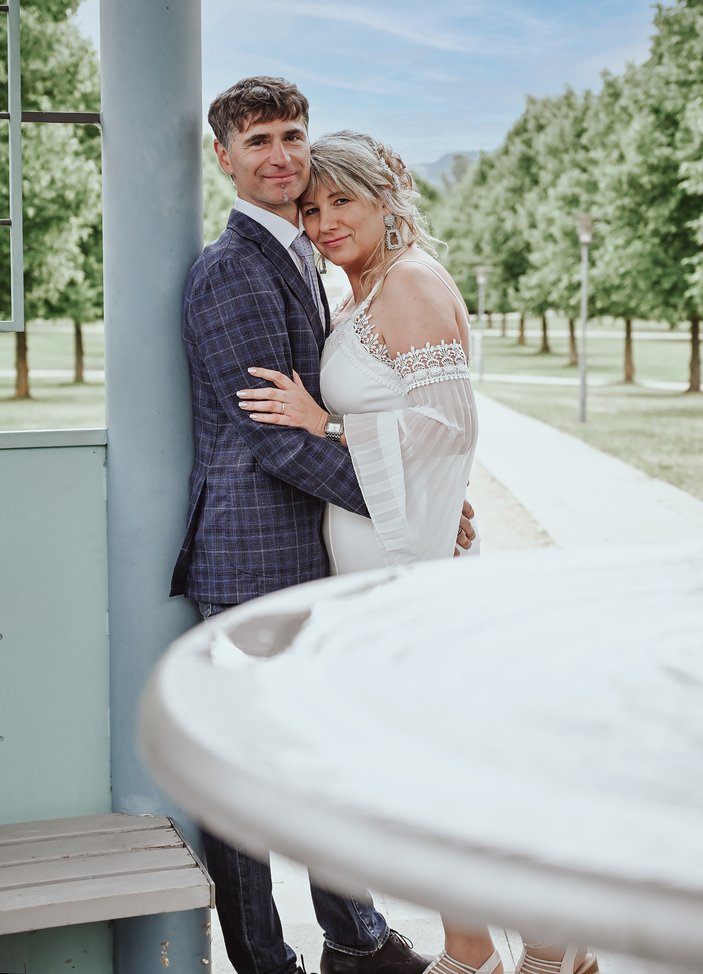 Paar in eleganter Kleidung umarmt sich liebevoll im Freien