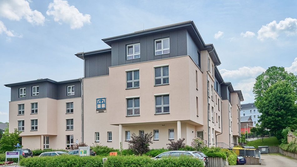 Modernes, helles Gebäude mit mehreren Etagen und Parkplatz