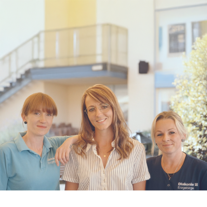 Drei Frauen lächeln gemeinsam in heller, freundlicher Außenumgebung