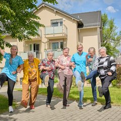 Pflegerin und Gäste heben die Beine
