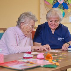 Senioren und Pflegerin am puzzeln 